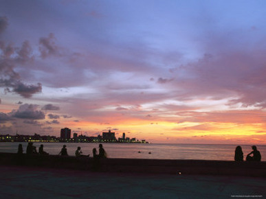 Twilight View of Young Cubans Sitting on City's Seawall