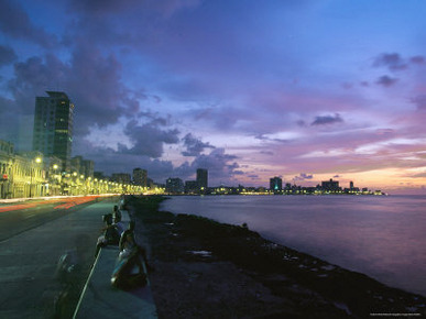 Twilight View of Young Cubans Sitting on City's Seawall